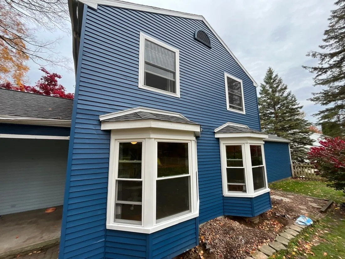 Interior view of a newly installed white bay window with wood trim